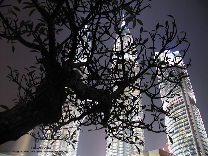 Petronas Twin Towers KLCC and KL Towers behind a crop / trees