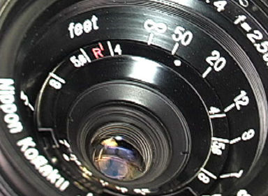 The distance scales and front lens element of the 25mm f/4.0 old Nikkor RF lens
