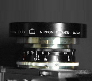 A Black version of  Nikon W-Nikkor-C 1:3.5 f=2.8cm (28mm f/3.5) wideangle lens in Nikon Bayonet S-Mount  mounted on a Nikon rangefinder camera